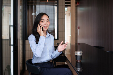 Businesswoman talking confidently on mobile phone in office