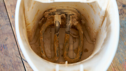 A detailed close-up view of an electric kettle's heating spiral, visibly encrusted with significant limescale deposits. This highlights the common issue of hard water buildup in household appliances.