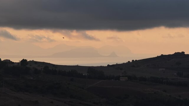 Aerial drone view of Capo Zafferano, a scenic Sicilian coastal promontory in the Metropolitan City of Palermo, Italy, featuring distant views of the Tyrrhenian Sea and the majestic Madonie Mountains