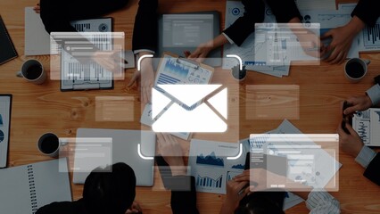 Engaging teamwork around a desk filled with business reports and digital devices, emphasizing...