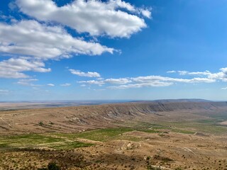 Scenic view of a mountain landscape and blue skies with clouds.