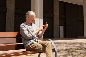 Senior person enjoying digital communication outdoors, technologies and gadgets
