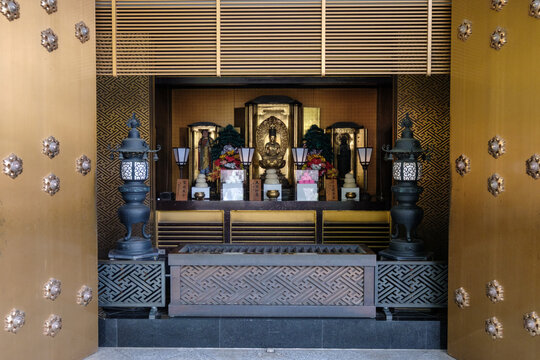 View of golden doors open to reveal an ornate altar with statues and lanterns, a serene pocket of reverence, Naritasan Shinsho-ji, Narita, Chiba, Japan.