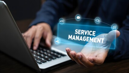 Business professional using laptop with glowing service management hologram