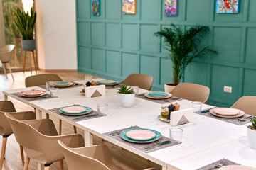 A Stylishly Set Dining Table with Elegant Dinnerware Surrounded by Modern Decor in a Bright and Inviting Space Perfect for Gatherings
