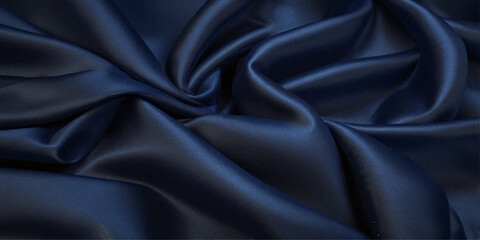Fototapeta premium Close-up of Draped blue Satin Fabric. A close-up view of luxurious black satin fabric with dramatic folds and drapes. 