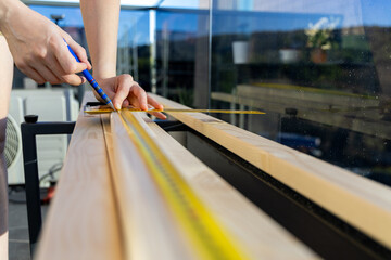 Wide angle of woman carpenter work on a wood project in home balcony. Self DIY project.