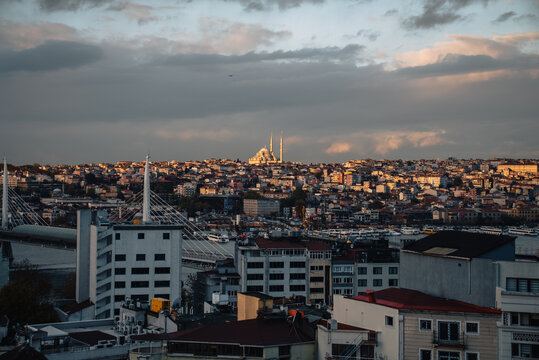 View of a sprawling cityscape under a dramatic sky, buildings below and a mosque in the distance with minarets piercing the skyline, Istanbul, &Auml;&deg;stanbul, T&Atilde;&frac14;rkiye.