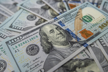 Pile of hundred US dollar bills, representing wealth and economic power.