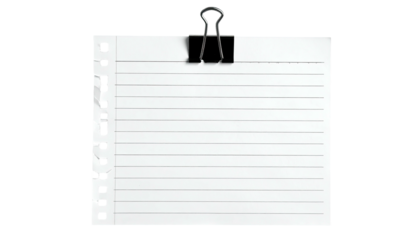 White ruled paper clipped at the top, with a black binder clip, against a black backdrop