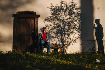 Elderly man waving goodbye to his younger self.