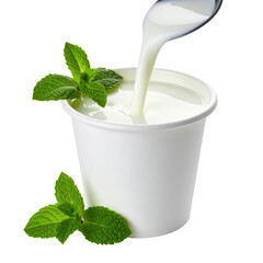 A scoop of creamy yogurt being poured from a spoon into a white paper cup with mint