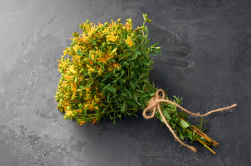 Freshly harvested thyme bouquet of vibrant green herbs tied with twine, showcasing natural textures and colors against a dark stone background, perfect for culinary or decorative use