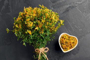 Freshly harvested thyme bouquet of vibrant yellow flowers tied with twine, accompanied by a heart-shaped bowl of dried petals, showcasing natural beauty and organic elements