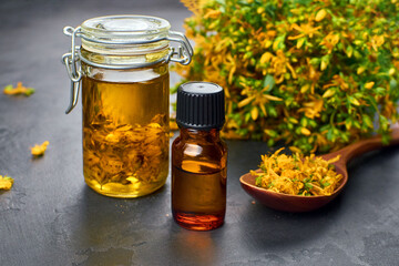 Herbal thyme oil in glass jars with fresh yellow thyme flowers on dark surface, showcasing natural ingredients and wellness concepts for holistic health and beauty applications