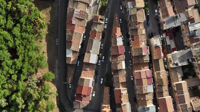 Aerial drone view of Collesano Sicilian mountain town at sunset with Basilica San Pietro church and historic stone streets in the Madonie Mountains, Sicily, Italy. Old mountain town in Sicily