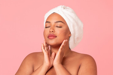 A woman enjoys a moment of relaxation while performing her skincare routine.