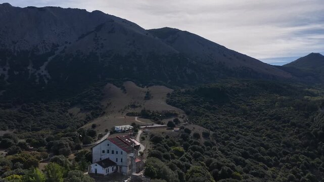 Aerial drone view of Piano Zucchi, a historic Sicilian mountain village at 1100 meters above sea level, surrounded by dense oak forests in the heart of Madonie Park, Isnello, Sicily, Italy