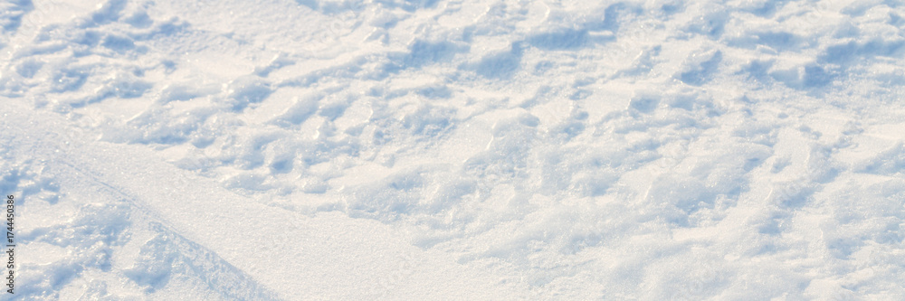 Wall mural beautiful winter background with snowy ground. natural snow texture. wind sculpted patterns on snow 