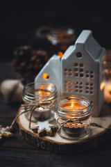 Creating holiday mood, festive atmosphere at home. Christmas spirit, atmospheric composition with handmade aroma candles made from simple glass jars, homemade gingerbread cookies, anise cinnamon scent