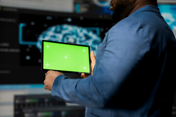 African American expert holds device with mockup screen with binary code in the background, digital transformation. Showcasing software development with algorithms, data science.