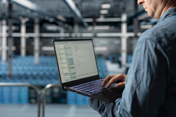 Close up of data center software developer analyzing supercomputers performance, resolving hardware bugs. Server farm IT specialist doing job tasks, coding, doing automatizations
