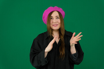 Collection of videos with young European woman in pink beret on green background expressing different emotions smiling thinking gesturing pointing down adjusting hair and posing with copy space.