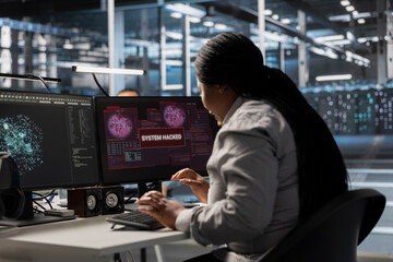 Data center software developer coding fixes after detecting irregular network activity patterns. African american server room IT expert trying to repair malicious threats using detection tools.