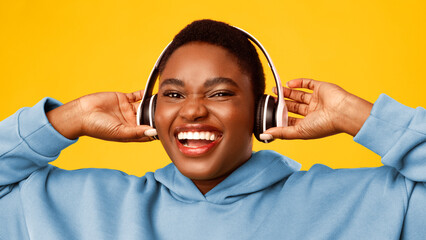 Joyful Overweight Black Woman Listening To Music Wearing Wireless Headphones Smiling To Camera...