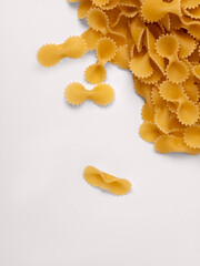 Uncooked farfalle pasta scattered on white background