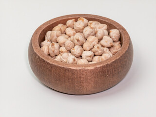 Dry chickpeas in wooden bowl on white background