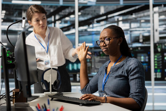 Data center employee being dismissive of manager berating her, reproaching performance issues. Rude technician in server hub ignoring verbal reprimand from irked team leader