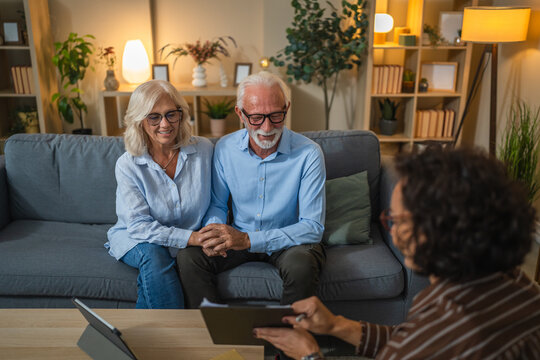 Senior couple engaged in negotiations with a consultant or agent - Powered by Adobe