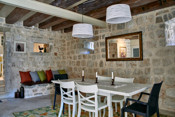 Charming Rustic Dining Space Featuring Stone Walls, Vintage Décor, and Elegant Lighting for a Cozy Atmosphere of Relaxation and Gatherings