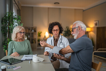 Doctor measuring blood pressure of senior patient at home