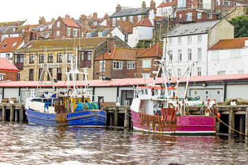 Fishing boats tied up to the quay in Whitby harbour, Yorkshire, England