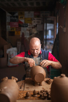 Potter making clay vessels in workshop