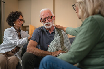 doctor listening to senior mans lungs with stethoscope during home medical