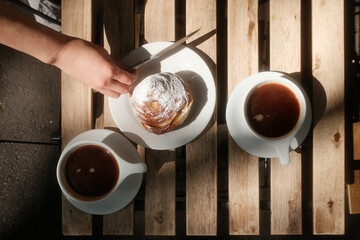 Morning Coffee and Pastry Enjoyed at a Cozy Wooden Table