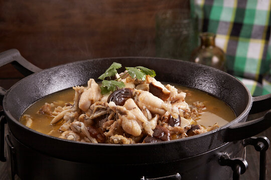 Wok-cooked herbal remedy with mushrooms and frog meat, closeup