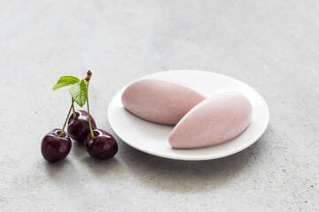 Vegan Cherry  dessert. Cherry cream quenelle. On a plate. Close-up