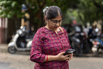 Indian woman speaking in a smartphone anxiously in the street  