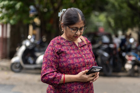 Indian woman speaking in a smartphone anxiously in the street  