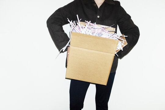Person holding brown classic cardboard boxes filled with paper chaff 