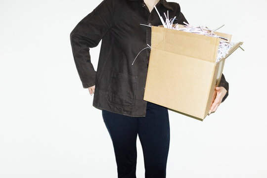 Person holding brown classic cardboard boxes filled with paper chaff 