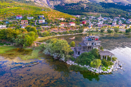 Aerial drone view of the beautiful landscape of Shiroka village beside lake at sunset near Shkoder, Albania