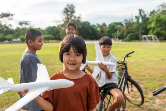 Rural youngest girl smiling brightly while holding foam glider
