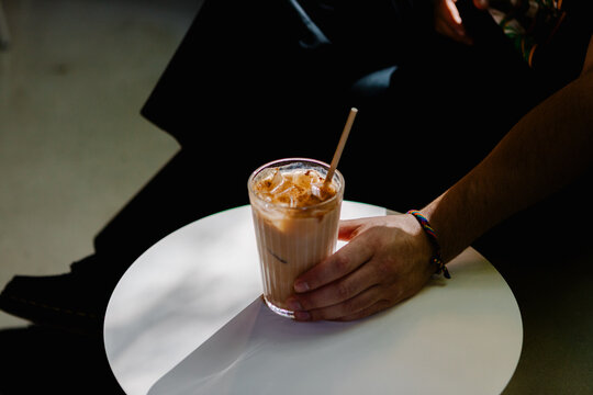 Unrecognizable hand gripping and sipping a chai latte tea
