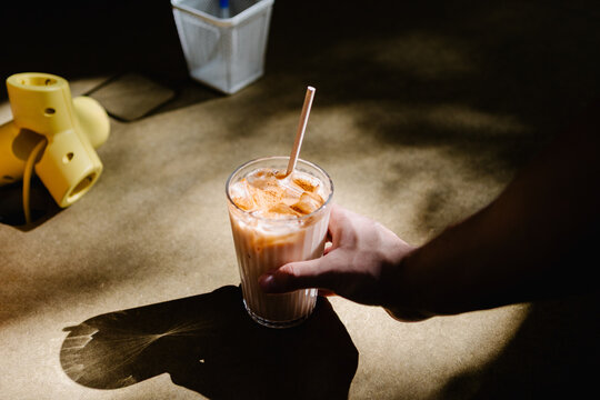 Unrecognizable person holding an iced coffee