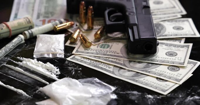 Illegal drugs and cash with gun and bullets on table - crime scene. Gun with bullets lying on the black table. Criminal problems. Drugs and money on black background. Illegal selling